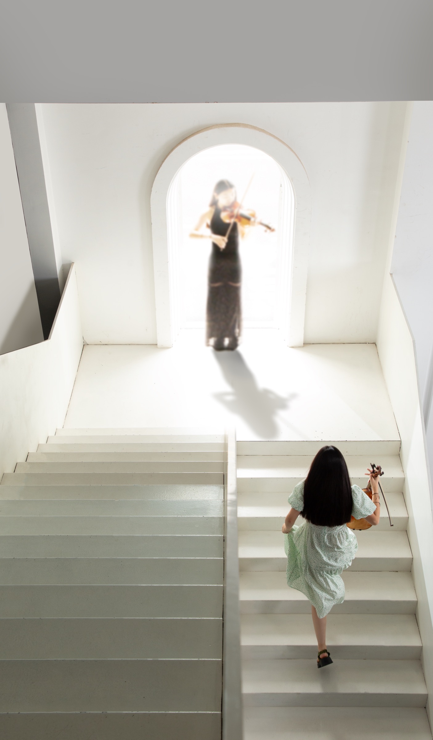 As a child in a pale dress, Calina climbs the white staircase toward the arch where a violinist plays.